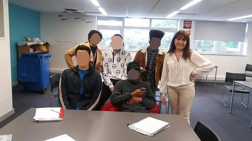 at desk with students